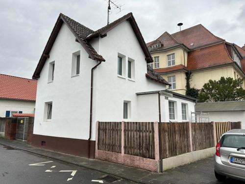 ein weißes Haus mit einem Zaun davor in der Unterkunft Sahra 1Zi. Wohnung Arheiligen in Darmstadt