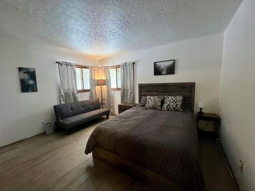 ein Schlafzimmer mit einem Bett und einer Couch in der Unterkunft Wagner Creek Hideaway in Munising