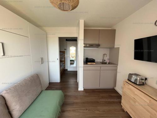 un salon avec un canapé et une cuisine dans l'établissement Studio cabine à 100m plage et commerces avec climatisation et parking - FR-1-100-326, à Cavalaire-sur-Mer