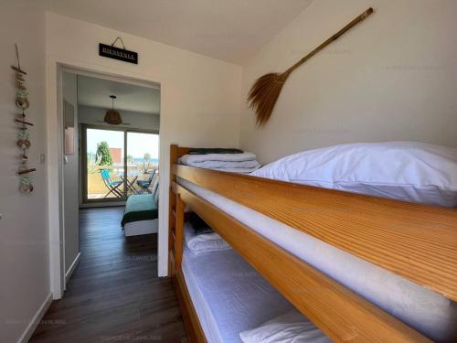 deux lits superposés dans une chambre avec balcon dans l'établissement Studio cabine à 100m plage et commerces avec climatisation et parking - FR-1-100-326, à Cavalaire-sur-Mer