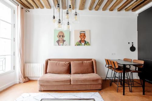 uma sala de estar com um sofá e uma mesa em Le Clos St Louis em Paris