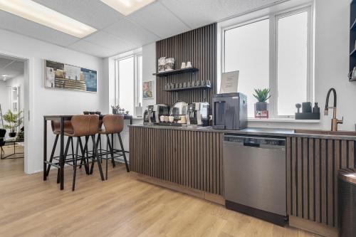 a kitchen with a counter and a bar with stools at Bank Guesthouse by KEF Airport in Keflavík