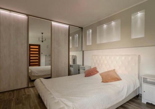 um quarto com uma grande cama branca e um espelho em Hacjenda Karaś em Iława