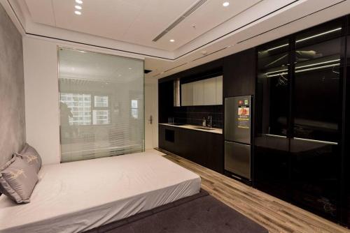 1 Schlafzimmer mit einem großen weißen Bett und einer Küche in der Unterkunft Vinhomes Smartcity - Zhomestay - Căn hộ dich vụ in Thượng Thôn