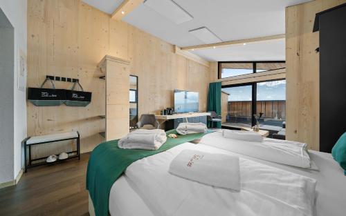 a bedroom with a large bed with white sheets at Aparthotel Zell am See (Contactless Check-In) in Zell am See