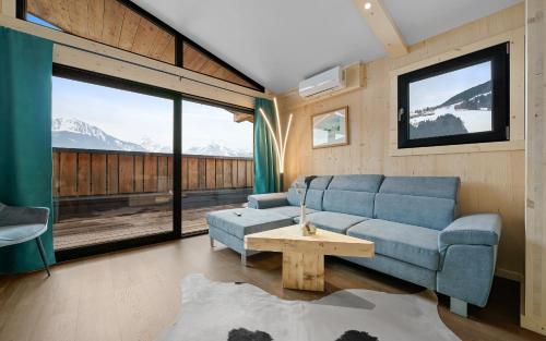 a living room with a blue couch and a table at Aparthotel Zell am See (Contactless Check-In) in Zell am See