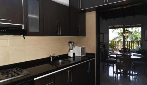 a kitchen with black cabinets and a table with chairs at Apartamento con espectaculares vistas en el centro histórico in Socorro