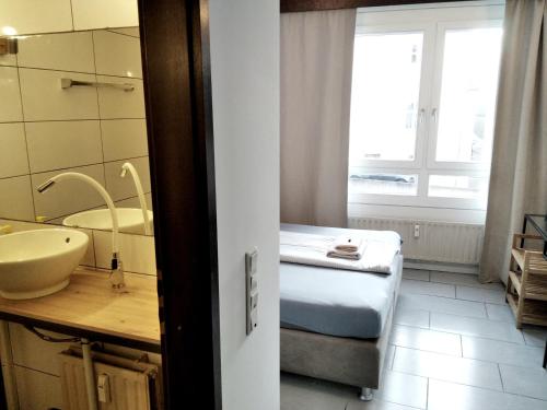 y baño con cama, lavabo y espejo. en Sroom 118 and 119 in Center, en Reutlingen