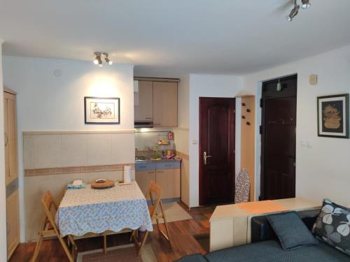 ein Wohnzimmer und eine Küche mit einem Tisch und einem Sofa in der Unterkunft Apartment Ilic in Zlatibor