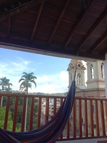 a hammock on a balcony with a clock tower at Apartamento con espectaculares vistas en el centro histórico in Socorro