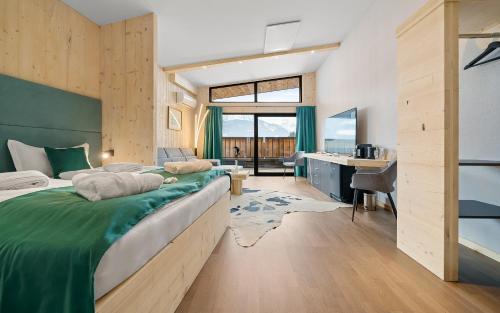 a bedroom with a large bed and a desk at Aparthotel Zell am See (Contactless Check-In) in Zell am See