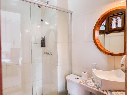 a bathroom with a shower and a toilet and a sink at Pousada Morada do Sol in Jericoacoara