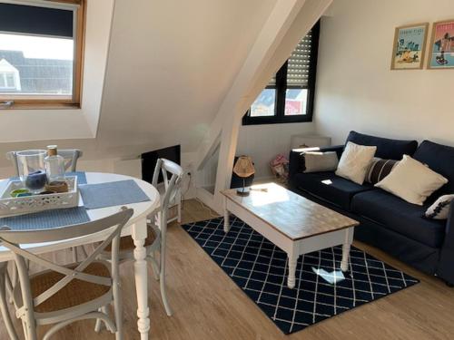 un salon avec une table et un canapé dans l'établissement TOUT A PIED ! T2 25m2 - Parking privé - Wifi, à Larmor-Plage