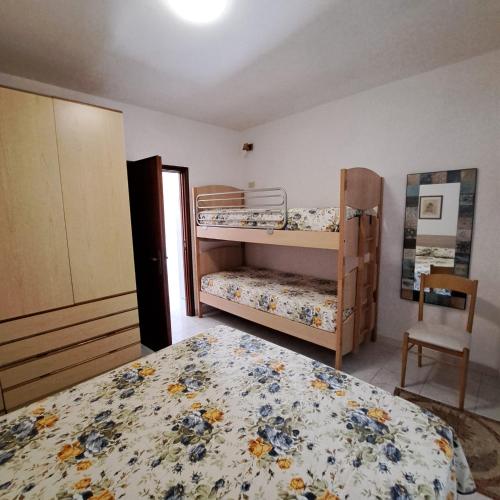 a bedroom with two bunk beds and a chair at Casa Costa e Manfredi in Chiessi