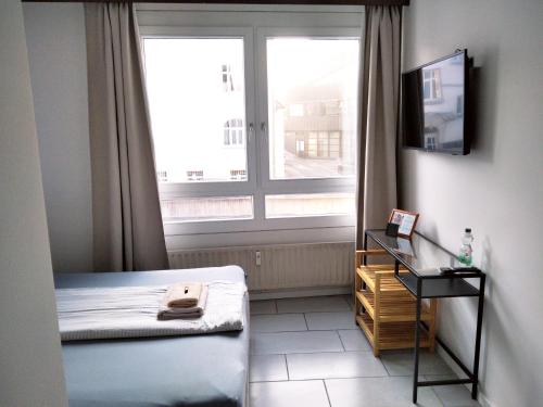 een kleine kamer met een bed en een raam bij Sroom 118 and 119 in Center in Reutlingen