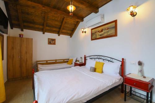 a bedroom with a bed with white sheets and yellow pillows at AMA Guest House in Turda