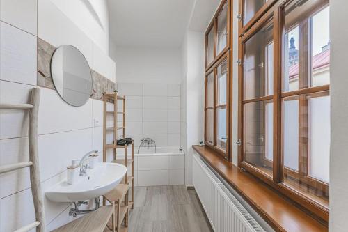 a bathroom with a sink and a mirror and a tub at Carolina's Yoga apartment in Hradec Králové