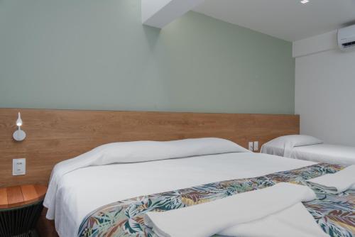 a bedroom with two beds with white sheets at Vistamar Hotel in Maceió