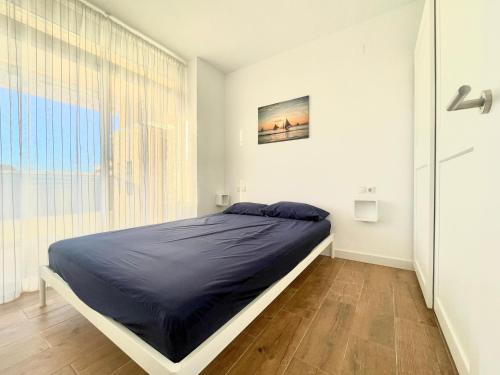 uma cama num quarto com uma grande janela em Costa Daurada Apartaments - AQUARIO PINEDA em La Pineda