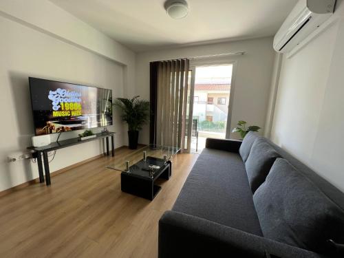a living room with a couch and a flat screen tv at Prince Boutique Apartment/1BR in Nicosia