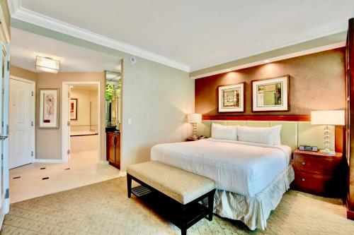 a bedroom with a large white bed and a chair at Strip View Suites - No Resort Fee ! in Las Vegas