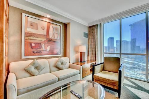 a living room with a couch and a chair at Strip View Suites - No Resort Fee ! in Las Vegas