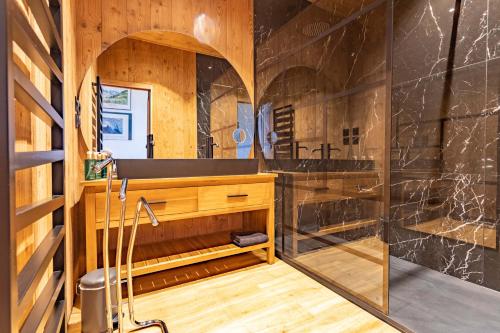 La salle de bains est pourvue d'une douche, d'un lavabo et d'un miroir. dans l'établissement Le petit Paradis, chalet au coeur des 3 vallées, à Saint-Marcel