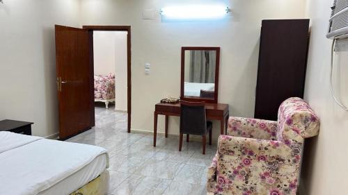 - une chambre avec un lit, un bureau et une chaise dans l'établissement نزل الخالدية, à Al Qunfudhah