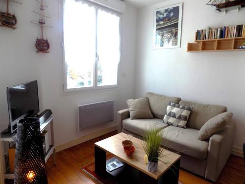 un salon avec un canapé et une table basse dans l'établissement Royan - APPARTEMENT au coeur du CENTRE-VILLE - PLAGE à 200m SEULEMENT, à Royan