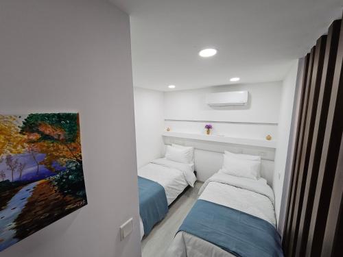 AlonaにあるTHE CLIFF ALONAの壁に絵画が飾られた部屋のベッド2台