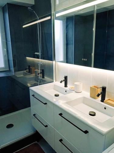 une salle de bain avec un lavabo blanc et un miroir dans l'établissement Superbe T3 terrasse et jardin centre bourg, à Caudan