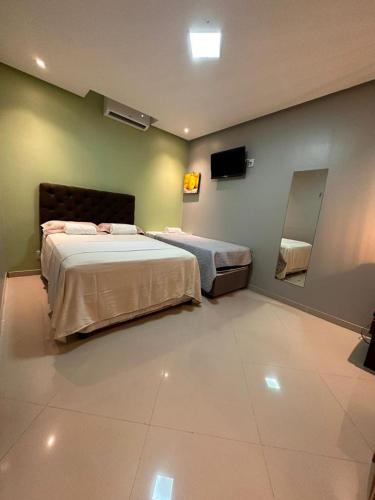 a bedroom with two beds and a mirror at Pousada Rekantu do Poeta in Alter do Chao