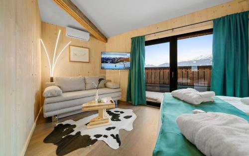 salon z kanapą, łóżkiem i oknem w obiekcie Aparthotel Zell am See (Contactless Check-In) w mieście Zell am See