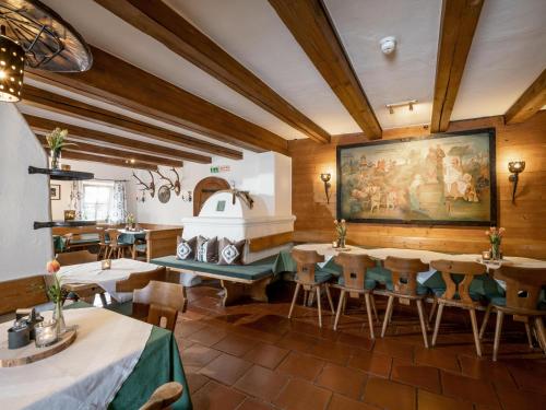 un restaurante con mesas y sillas y una pintura en la pared en Fuchswirt Kelchsau Landgasthof-Hotel, en Hopfgarten im Brixental