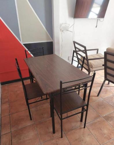 ein Holztisch und Stühle in einem Zimmer in der Unterkunft Buganvilias Quepos No. 1 in Quepos