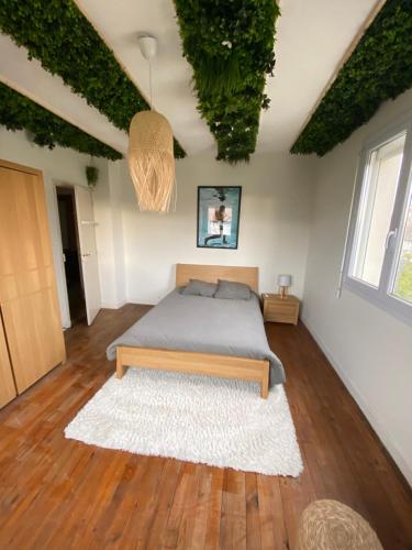 Maison de ville 5 chambres, piscine في بورت-ليه-فالونس: غرفة نوم بها سرير وزرع على الاسقف