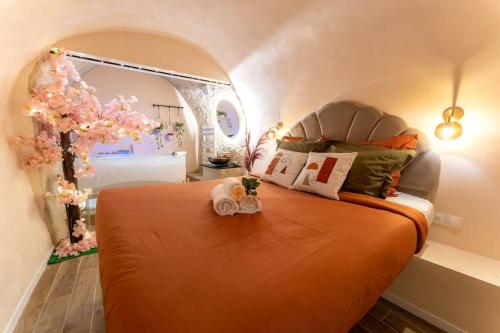 une chambre avec un lit avec un couvre-lit orange dans l'établissement Love Room avec 2 Jacuzzi Balnéo, Parking, à Nice