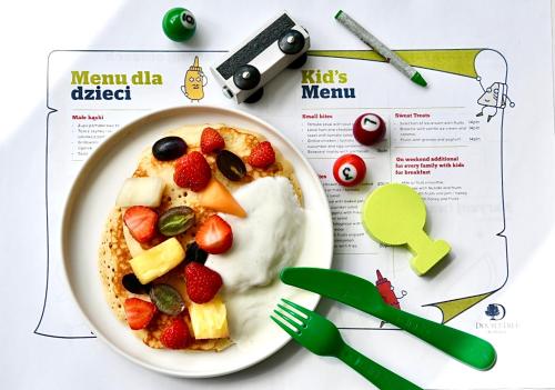 a plate of food with fruit and yogurt on a table at DoubleTree by Hilton Wroclaw in Wrocław