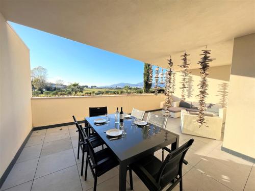 une salle à manger avec une table et des chaises sur un balcon dans l'établissement Appartement Le Frasso PORTICCIO, à Porticcio