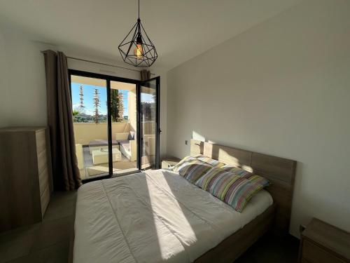 - une chambre avec un lit et une vue sur une terrasse dans l'établissement Appartement Le Frasso PORTICCIO, à Porticcio