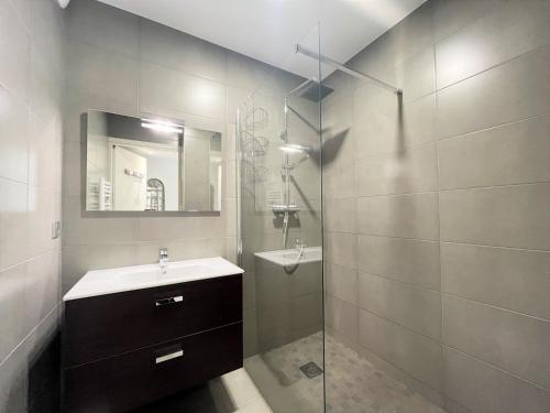 une salle de bain avec un lavabo et une douche en verre dans l'établissement Appartement Le Frasso PORTICCIO, à Porticcio