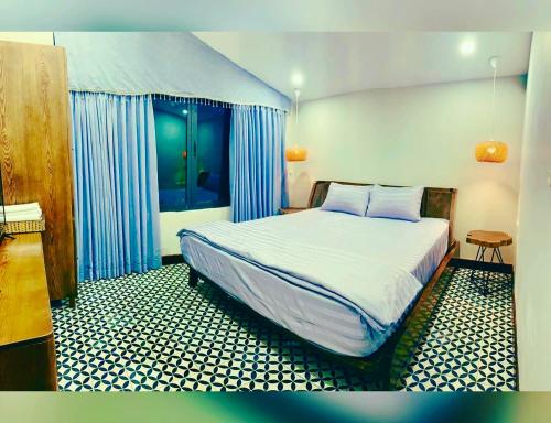 a bedroom with a large bed with blue curtains at KaoCat Sea Villa w/3BR 2BA AC 3km to DT & NightMK in Phú Quốc
