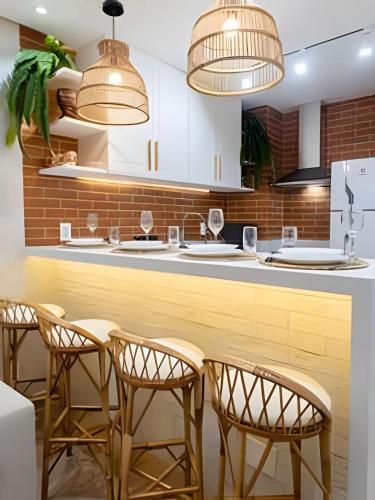 a kitchen with wooden chairs and white cabinets at Copa Beach Studios Design in Rio de Janeiro