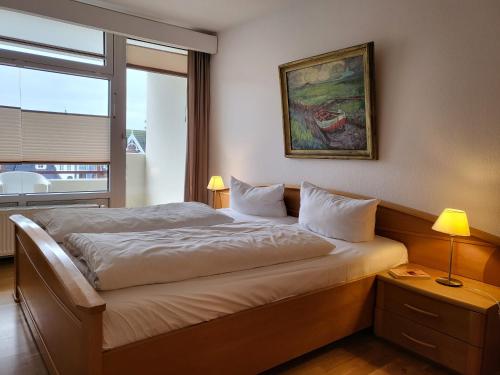 een slaapkamer met een groot bed en een raam bij Apartment 41 im Haus Villa Anna in Sankt Peter-Ording