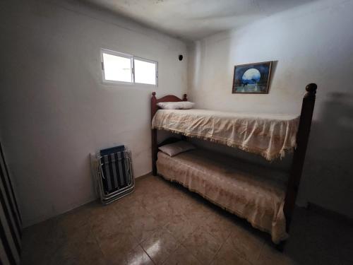 een kleine slaapkamer met een bed en een raam bij casa de verano centro Necochea in Necochea