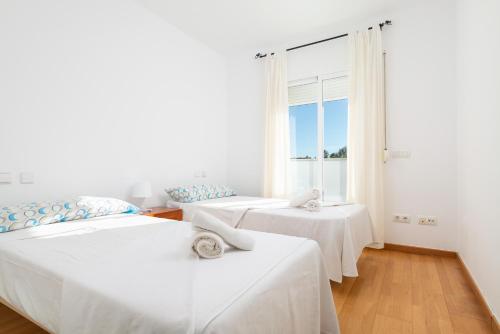 two beds in a room with a window at Impresionante Villa Son Ganxo II en Cala Murada! in Cala Murada