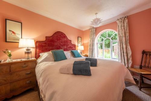 a bedroom with a large bed and a window at The Gate House in Wymondham