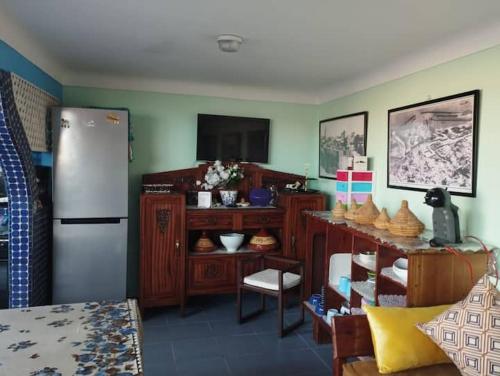 Il comprend une cuisine équipée d'un réfrigérateur et d'une table avec des chaises. dans l'établissement Dar El jadida, à El Jadida