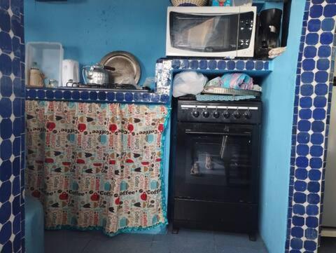 a small kitchen with a stove and a microwave at Dar El jadida in El Jadida