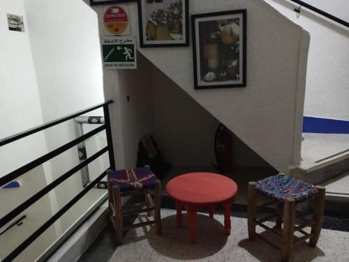 a stairway with two chairs and a red stool at Dar El jadida in El Jadida